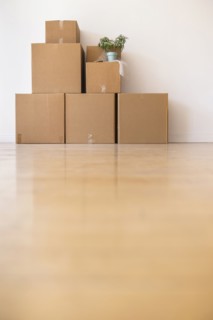Cardboard boxes stacked against wall in empty apartment
