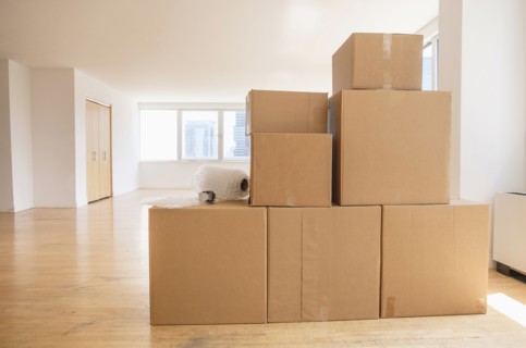 Cardboard boxes and bubble wrap in empty apartment