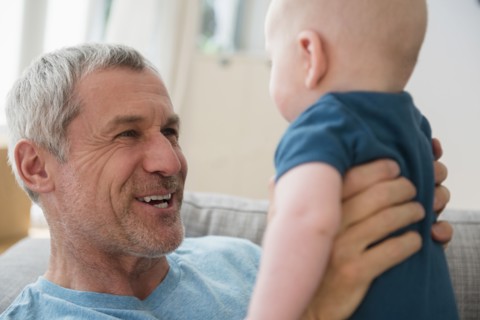 Caucasian grandfather holding grandson face to face