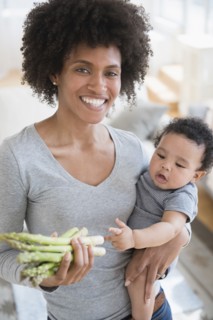 Mother holding asparagus and baby son