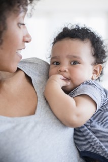 Mother holding teething baby son