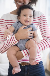 Smiling mother holding baby son