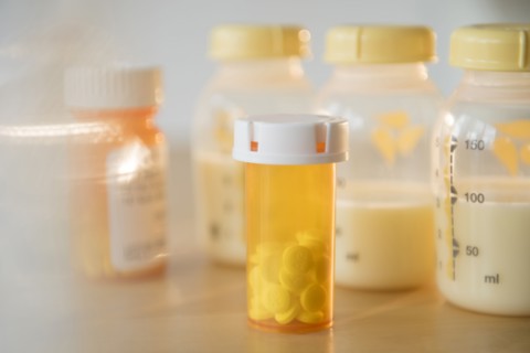 Bottle of prescription pills and bottles of breast milk