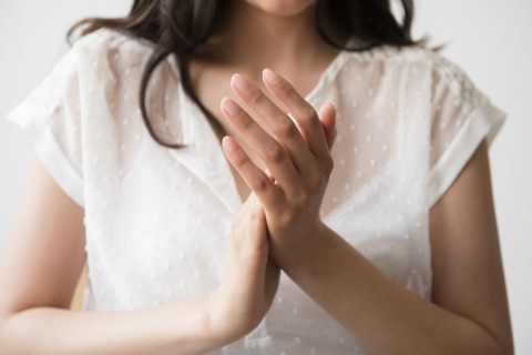 Hispanic woman rubbing hands