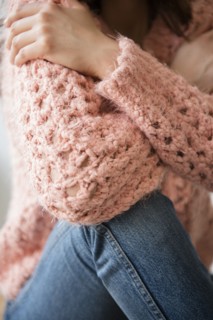 Hispanic woman wearing pink sweater and jeans