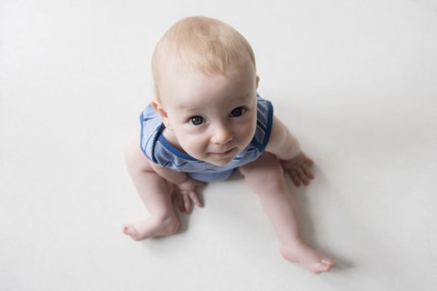 Caucasian boy sitting on floor looking up