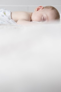 Caucasian baby boy sleeping on bed