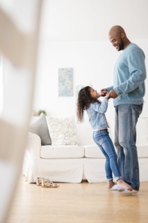 Daughter standing on feet of father and dancing