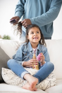 Father brushing hair of daughter