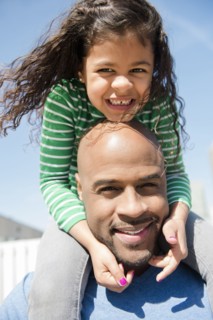 Father carrying daughter on shoulders