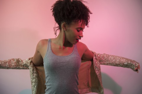 Black woman dressing in glamorous jacket
