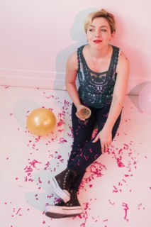 Caucasian woman sitting on floor at party covered in confetti