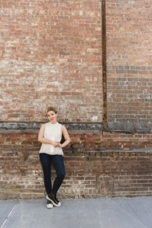 Caucasian woman leaning on brick wall