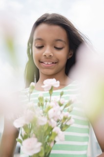 Mixed Race girl holding bouquet of flowers
