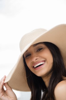 Smiling Mixed Race woman wearing sun hat