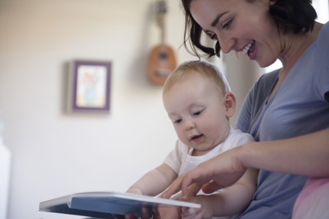 Caucasian mother reading book to baby son