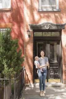 Caucasian mother standing near doorway holding baby son