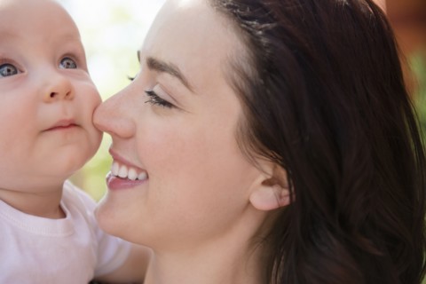 Caucasian mother rubbing nose on cheek of baby son