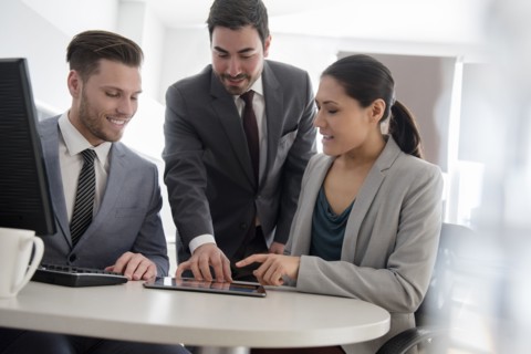 Business people talking in office using digital tablet and computer