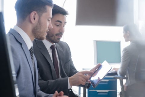 Businessmen using digital tablet in office