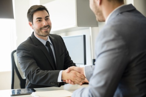 Businessmen shaking hands in office