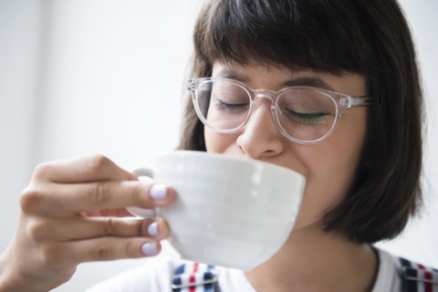 Hispanic woman drinking coffee