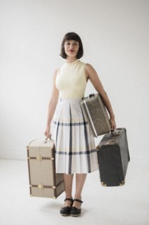 Portrait of smiling Hispanic woman holding suitcases