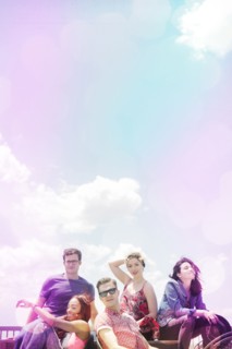 Portrait of smiling friends under sunny sky