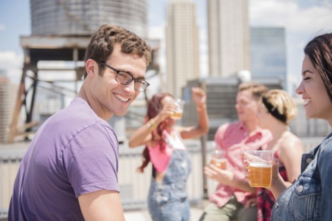 Smiling couple drinking beer outdoors