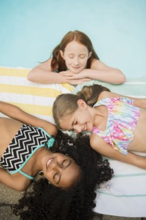 Smiling girls relaxing at swimming pool