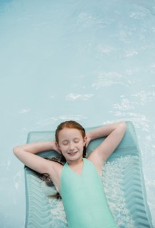 Caucasian girl floating on pool raft in swimming pool