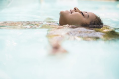 Surface level view of Hispanic girl floating in swimming pool