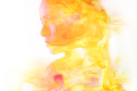 Double exposure of face of Mixed Race woman and fire