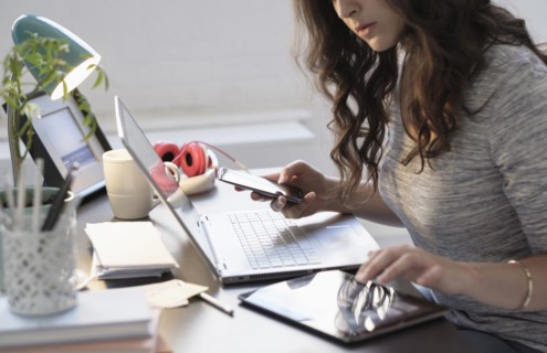 Hispanic businesswoman using technology in office