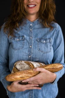 Smiling Caucasian woman holding bread