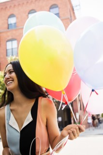 Thai woman holding balloons in city