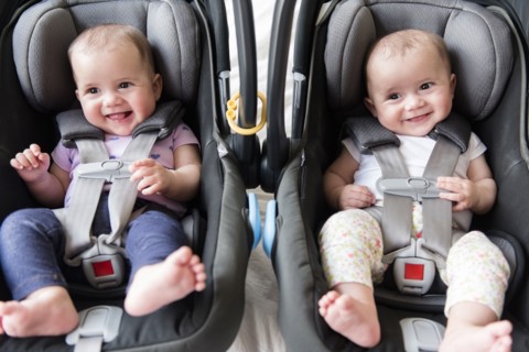 Caucasian twin baby girls in car seats