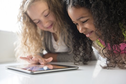 Smiling girls using digital tablet