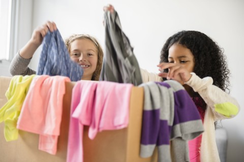 Girls examining box of clothing