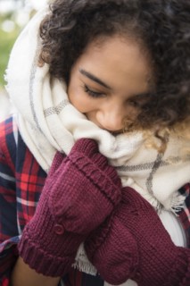 Mixed Race woman covering face with scarf