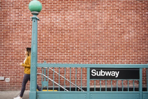 Mixed Race woman exiting subway station in city