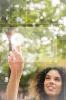 Mixed Race woman pointing to virtual screen outdoors