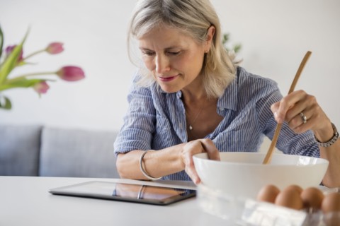 Caucasian woman baking with recipe on digital tablet