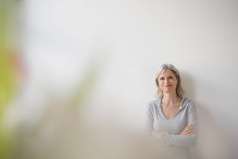 Smiling Caucasian woman leaning on wall