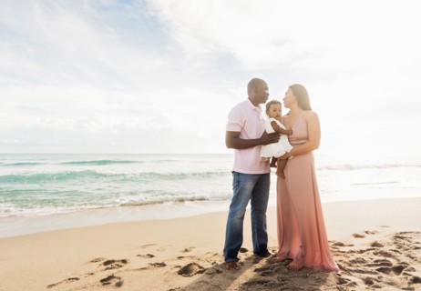 Couple holding baby daughter on beach