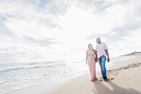 Couple holding hands walking on beach