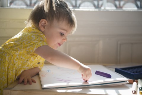 Caucasian baby girl coloring on sketchpad