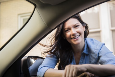 Smiling Caucasian woman leaning in car window