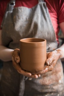 Caucasian woman showing pottery cup