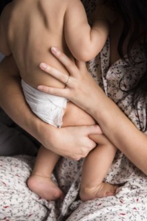 Caucasian mother holding baby son in bed